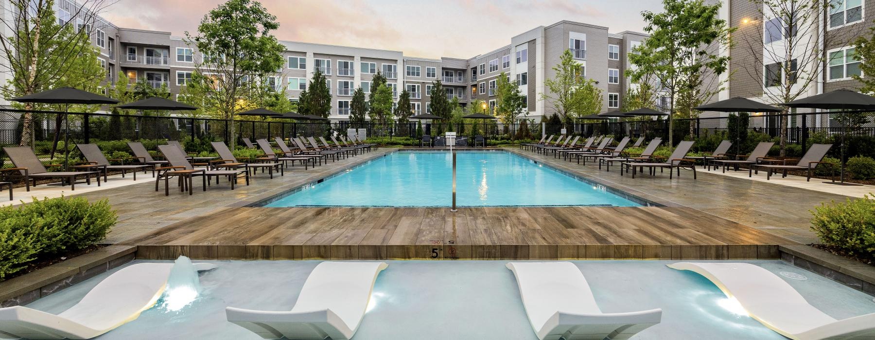 a pool with lounge chairs around it